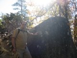 Man standing next to Rock