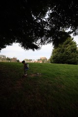 Child Exploring Park Under Overcast Sky