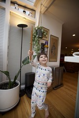 Joyful Child Playing with Wooden Sword in Cozy Home