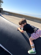 Young Boy Peering Over Urban Skateboard Ramp Edge