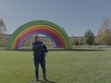 Man Posing at Colorful Rainbow Art Installation