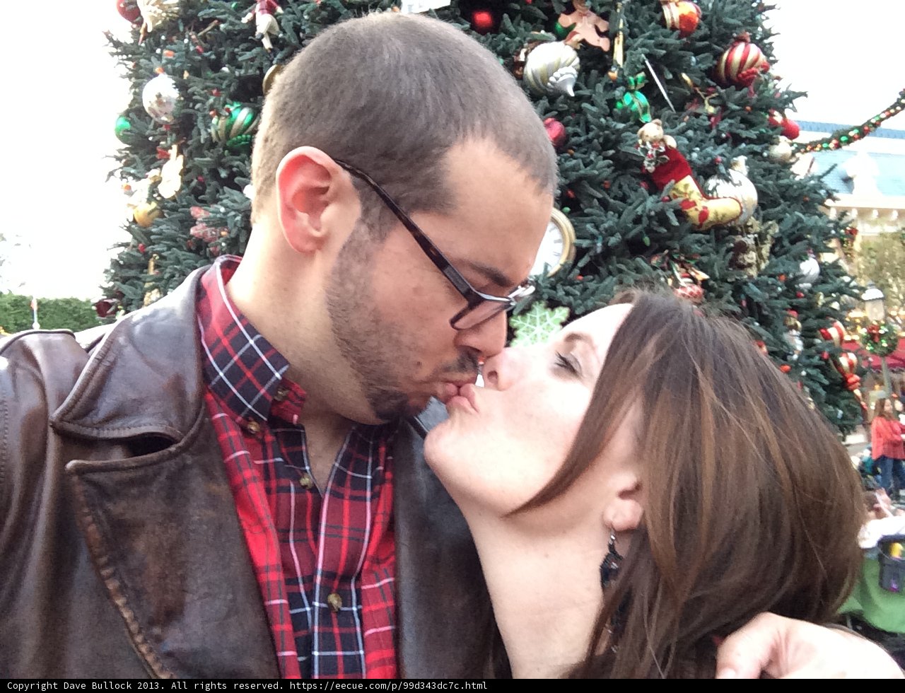 Romantic kiss in front of Christmas tree