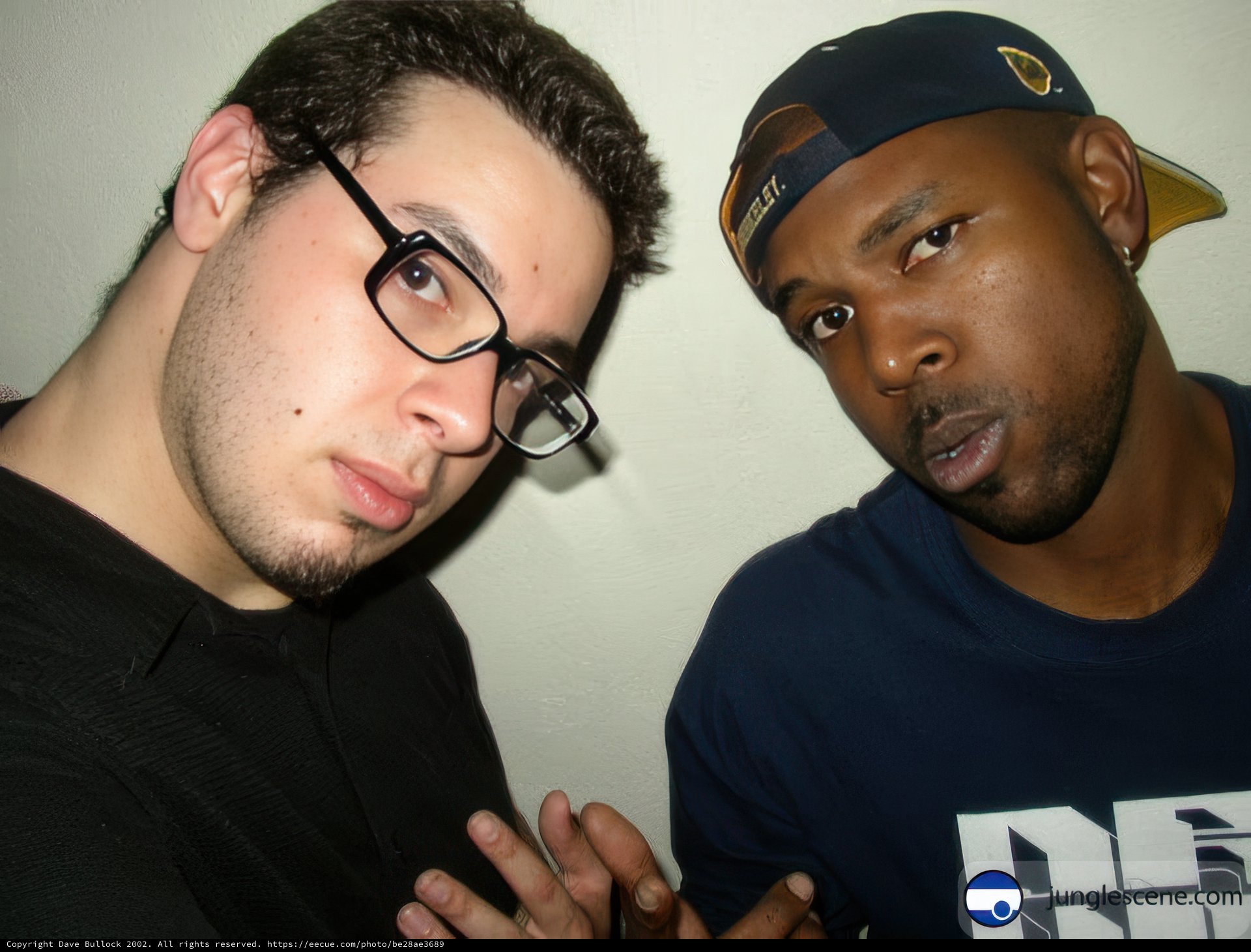 Two Men in Glasses and Hats Pose for a Portrait