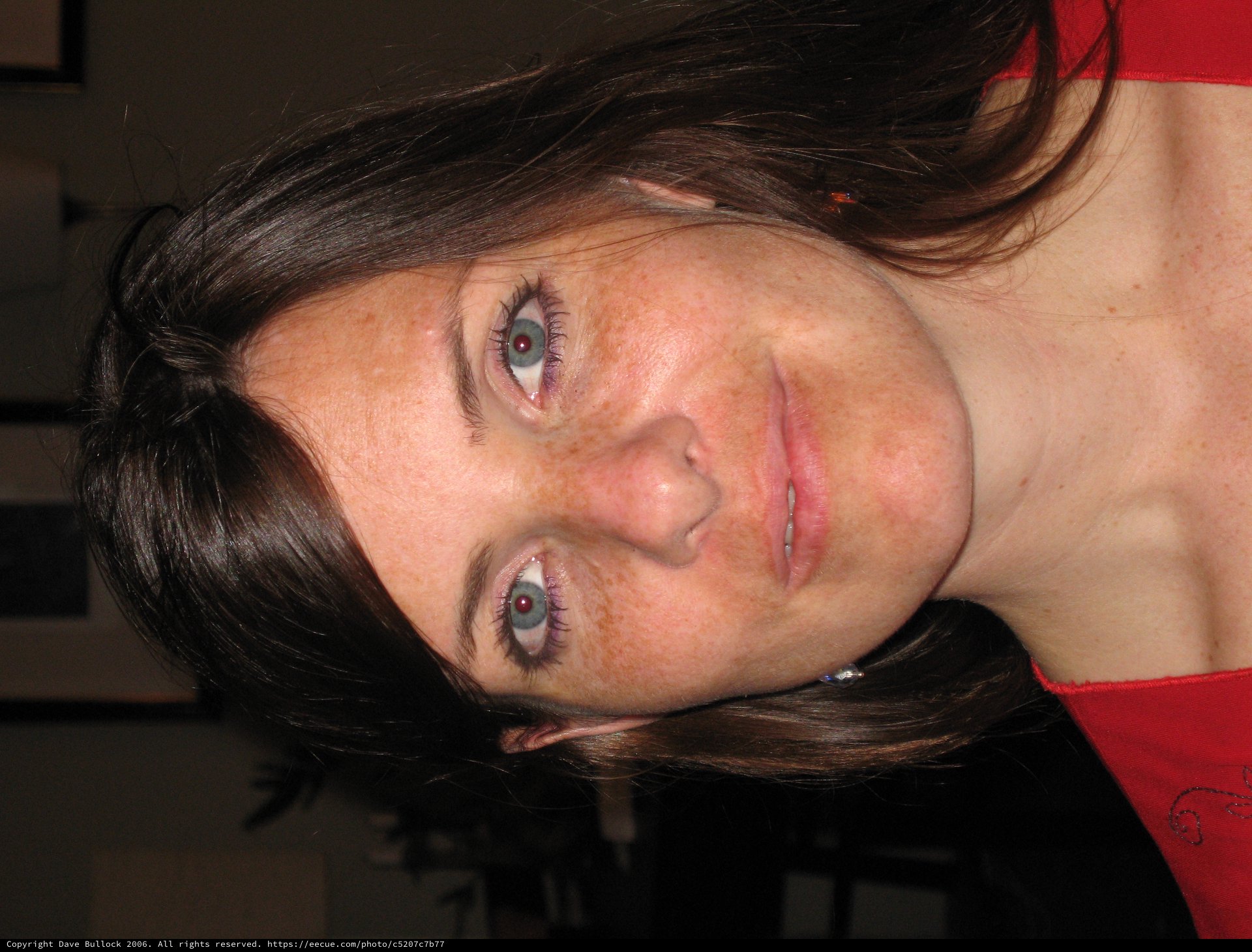 Freckled Woman in Red at Indoor Gathering