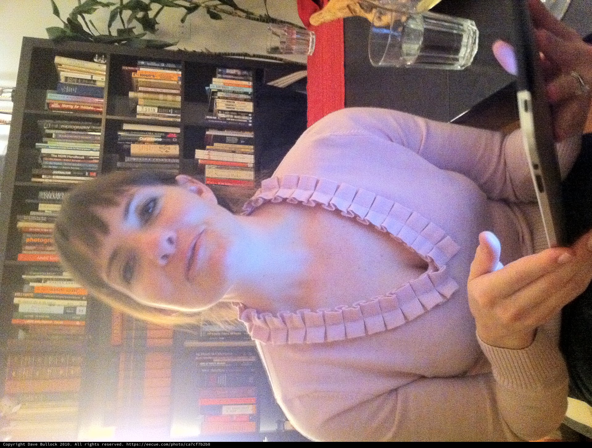 Woman with Tablet in Cozy Home Library Setting