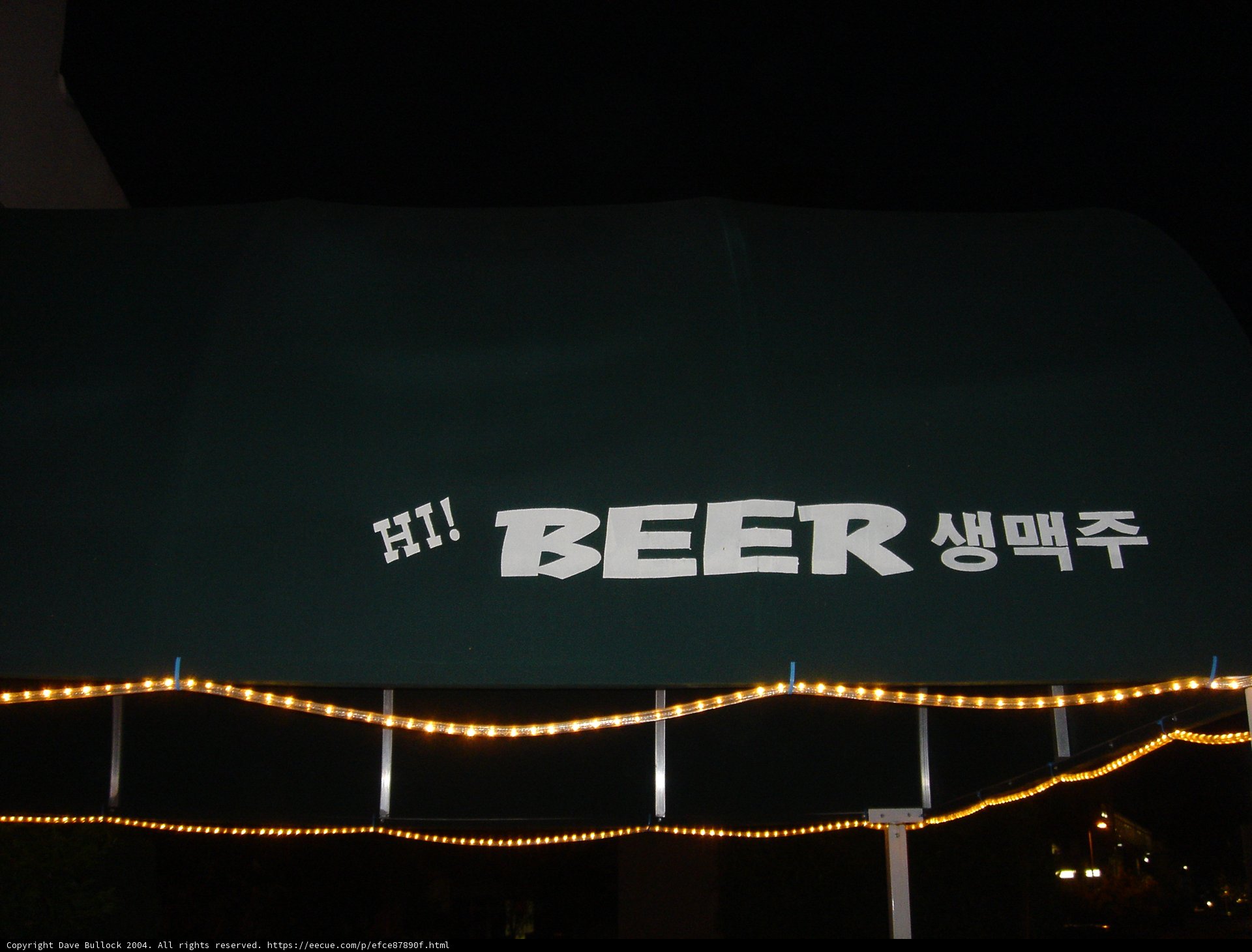 Green Canopy with Beer Sign at Night