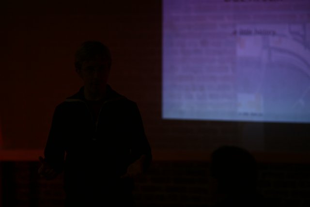 Man presenting in front of a projection screen