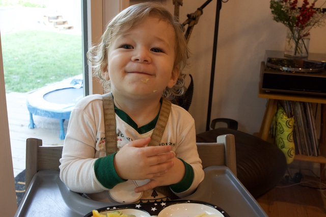 Joyful Toddler Enjoying Christmas Eve Meal at Home