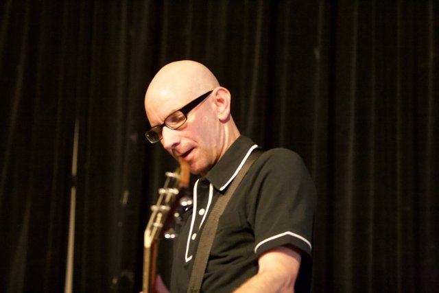 Bald Man with Glasses Strums a Tune