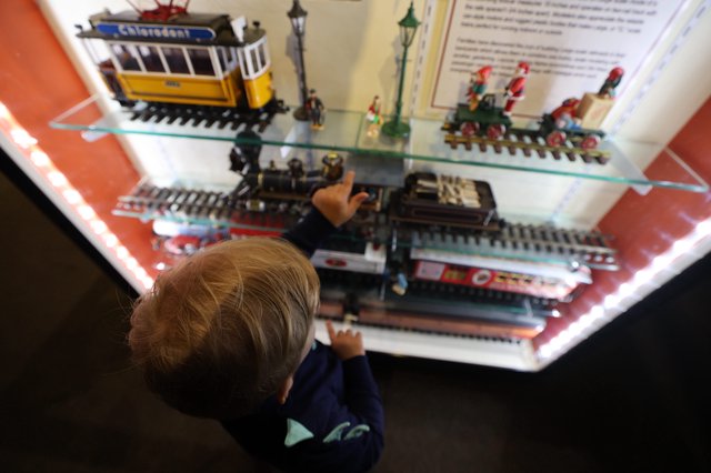 Child Exploring Miniature Train Display at Museum