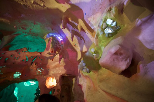 Illuminated Fantasy Cave Interior with Colorful Sculptures