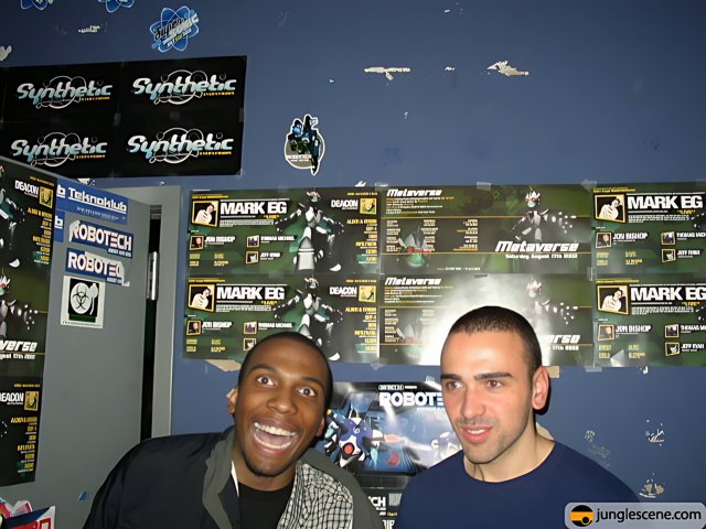Two Men Posed in Front of Computer Hardware Posters