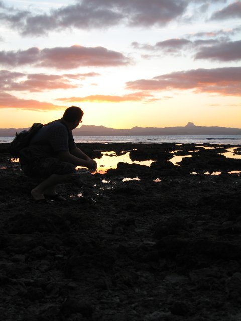 Kneeling by the Ocean at Sunset