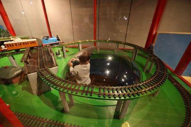 Child Operating Model Train Set at Interactive Museum Display