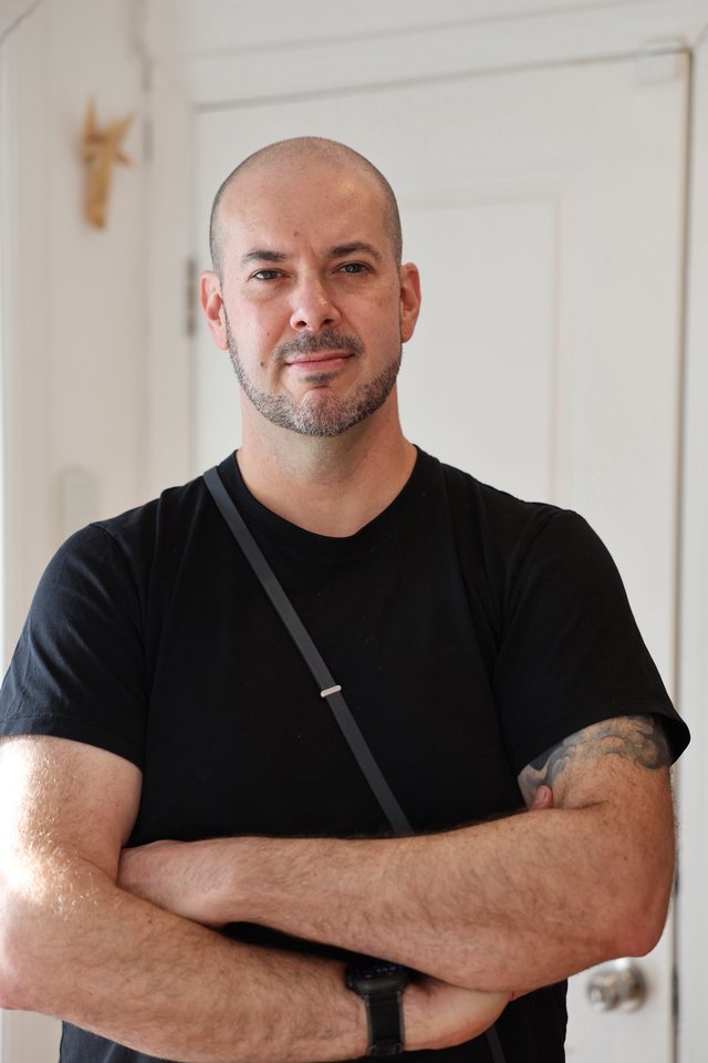 Confident Portrait of Bald Man with Tattoo in Modern Interior