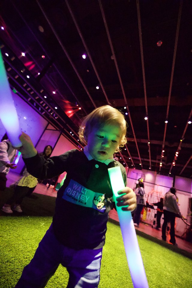 Young Child with Light Saber at Baby Rave Event