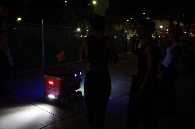 Coco Delivery Robot Encounters Festival Goers at Night