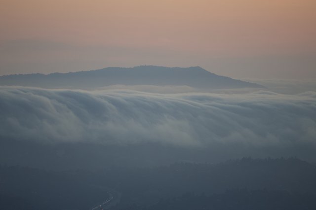 Fog Cascades Over the Hills at Twilight