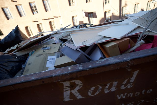 Overflowing Recycling Dumpster in Historic Urban Setting