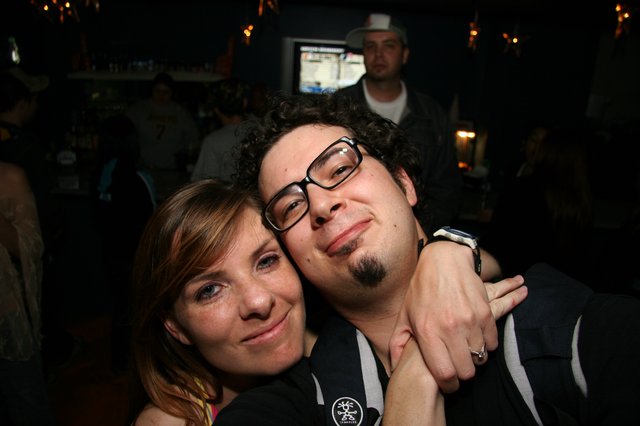 Friends Embrace at a Dimly Lit Bar Night