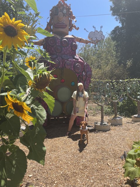 Woman and Dog Admiring Giant Floral Statue