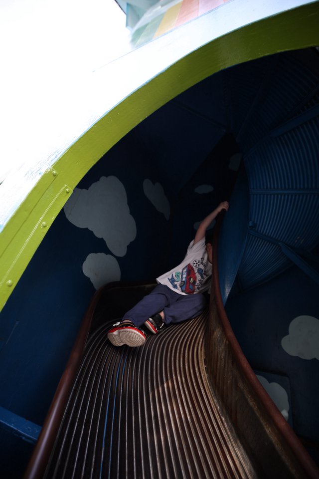 Child Descending Through Colorful Tunnel Slide