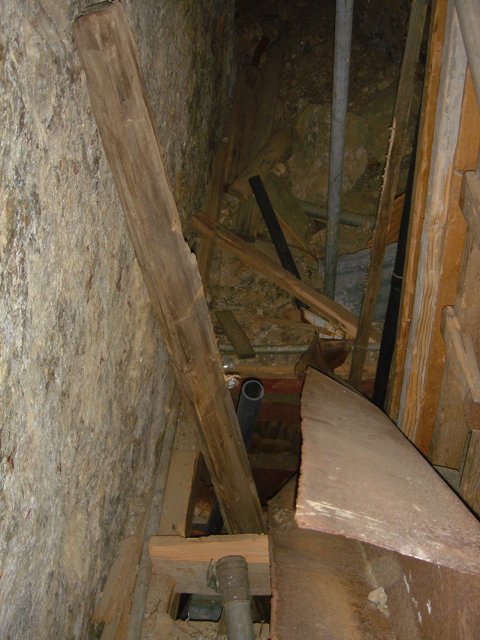 Leaning Plywood Beam in Dungeon-like Room