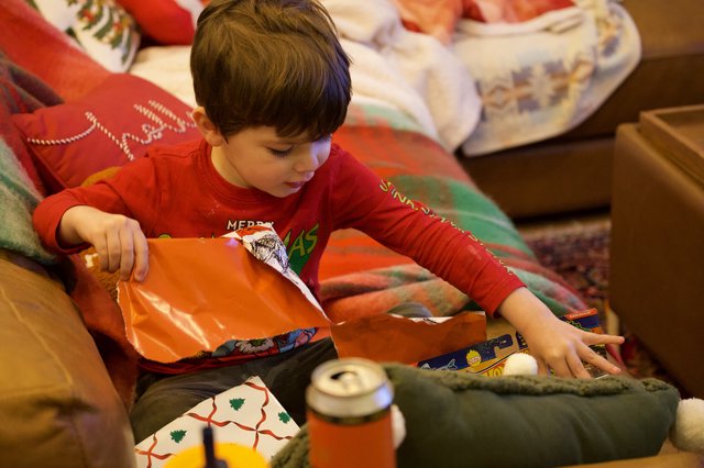 Young Boy Unwrapping Christmas Presents on Christmas Morning