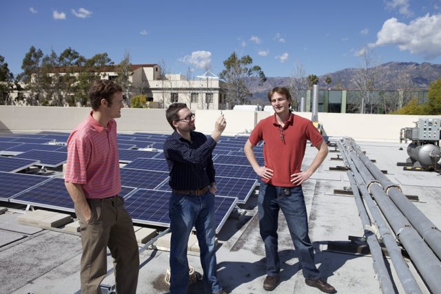 Three Men Installing Solar Panels on a Rooftop