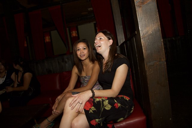 Two Women Laughing Together at a Dimly Lit Bar