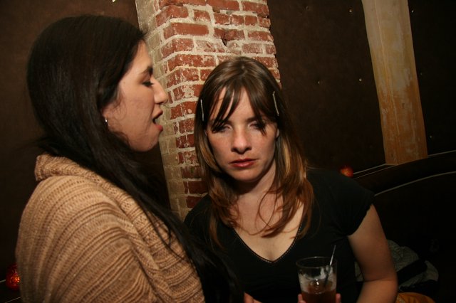 Two Women Conversing at a Dimly Lit Bar