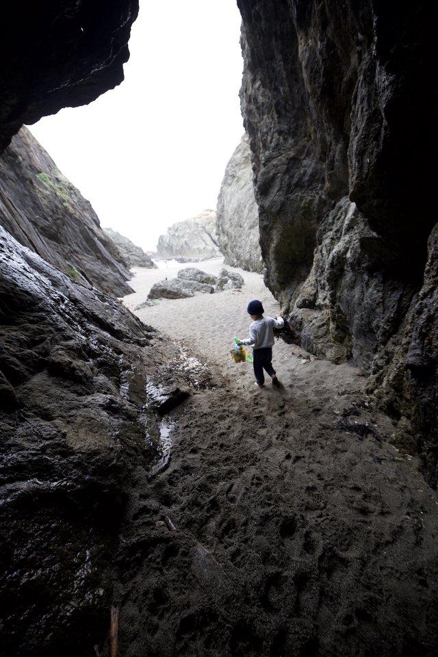 Child Explorer Ventures Through Coastal Sea Cave