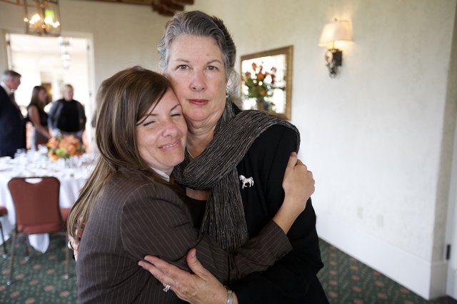Two Women Share Emotional Embrace at Funeral Reception