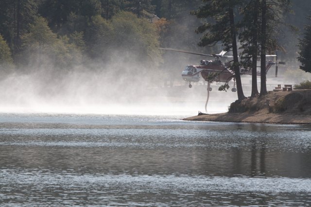 Helicopter Spraying Water on Lake