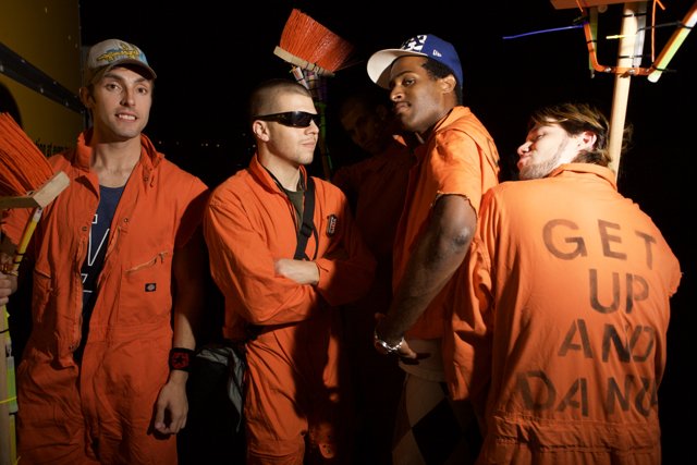 Group of Men in Orange Jumpsuits at Work Site