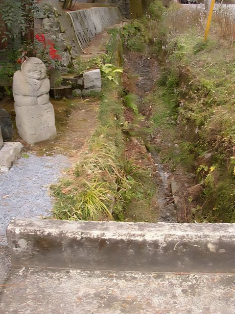 Serene Stream with Stone Statue