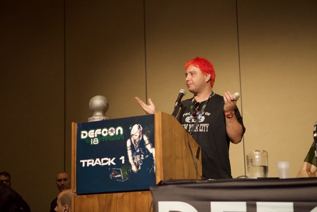 Red-haired speaker addresses crowd at DefCon 18