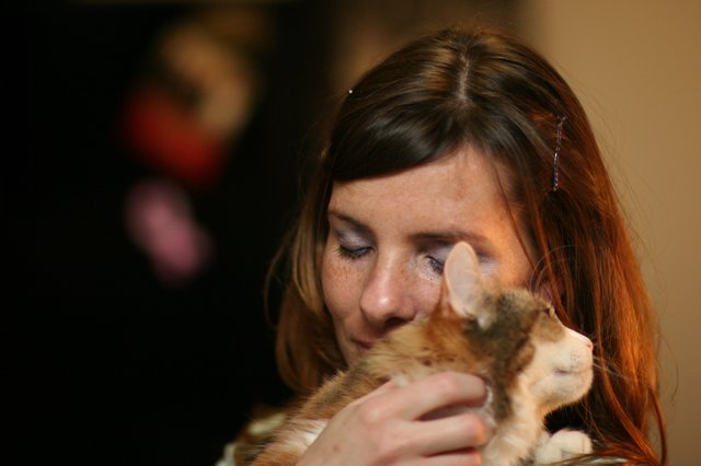Tender Moment: Woman Nuzzling Ginger Kitten Lovingly