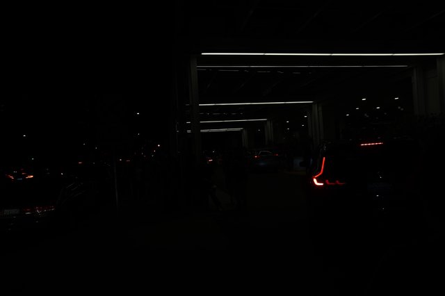 Red Taillights Glow in Dark Parking Structure Night