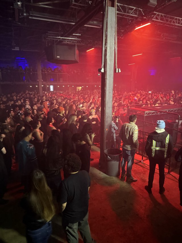 Red-Lit Concert Crowd from Side Stage View