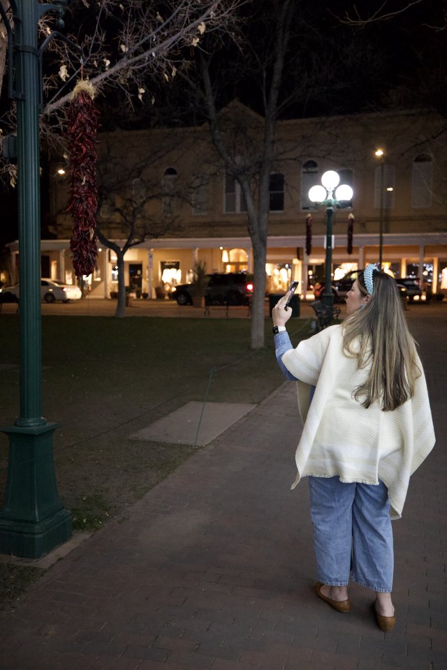 Woman Photographing Plaza Decorations at Night in Santa Fe