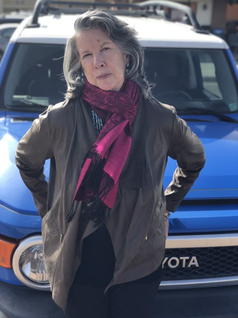 Stylish Rhoda B poses in front of her blue Toyota truck