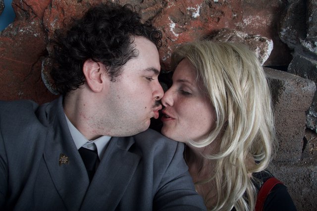 Romantic Halloween Kiss Against Rustic Brick Wall