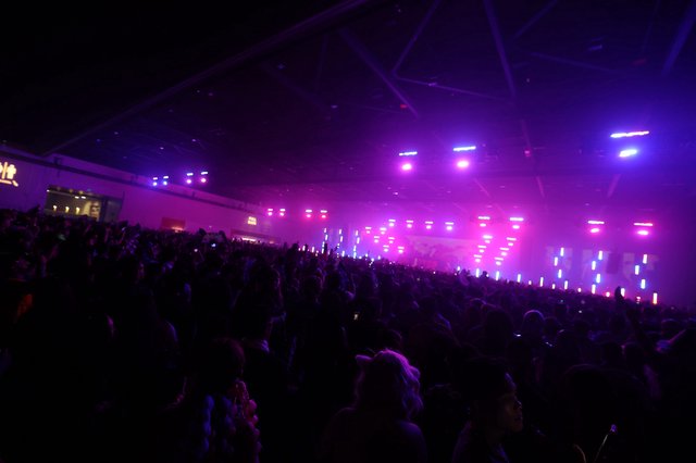 Massive Indoor Crowd Bathed in Purple Concert Lights