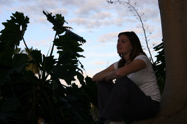 Woman Contemplating at Dusk Among Tropical Foliage