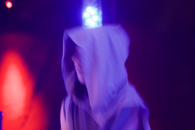 Hooded Figure Caught in Red Light