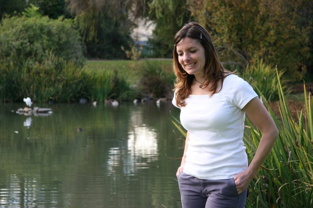 Woman Smiling by a Peaceful Park Pond