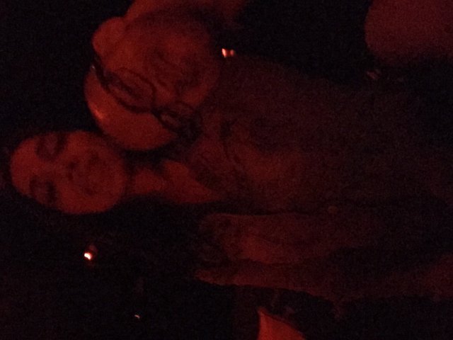 Two Friends Sharing a Moment in Red-Lit Darkness