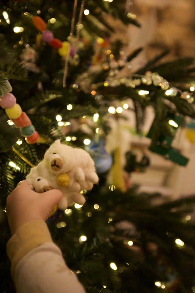 Child's Hand Holding White Snowman Christmas Ornament