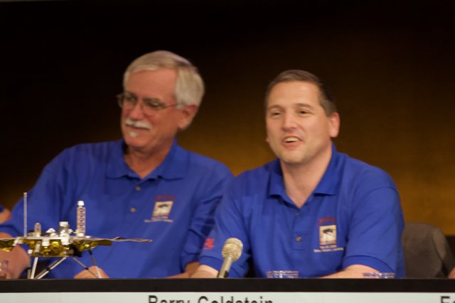 Press Conference Featuring Two Men in Blue Shirts at Phoenix Landing